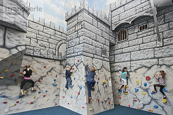Kinder bouldern auf einer Burg wie einer Kletterwand