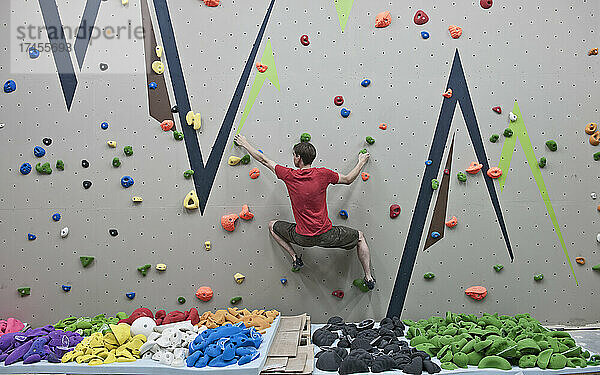 Routensetzer probiert neue Boulderprobleme an der Indoor-Kletterwand aus
