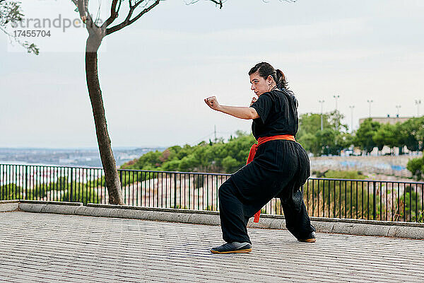 Frau in Uniform übt Kampfsport in einem Park