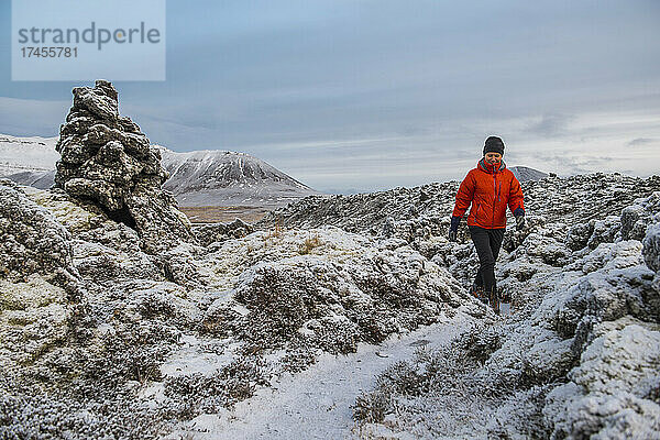 Frau wandert durch gefrorene Landschaft in Island