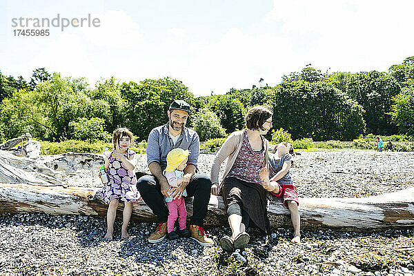 Direkter Blick auf eine Familie  die zusammen am Strand sitzt