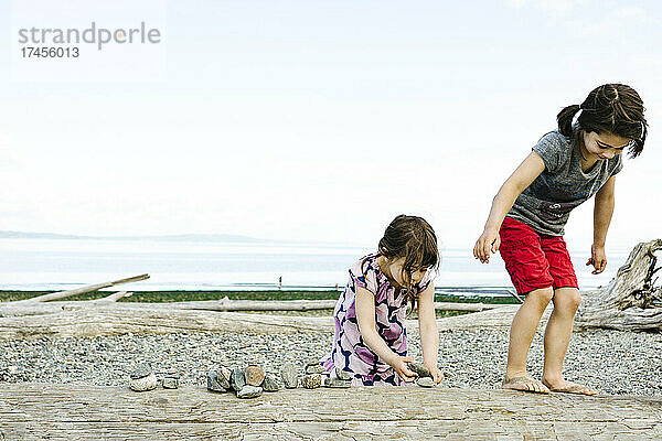 Zwei junge Mädchen spielen zusammen am Ufer des Puget Sound