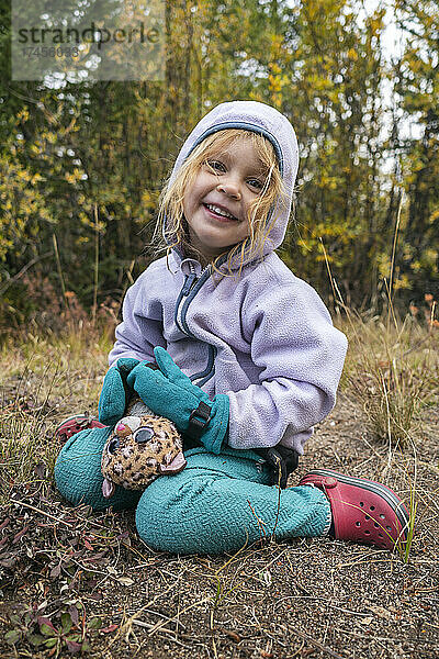 Glückliches Mädchen mit Spielzeug in der Wildnis  Colorado