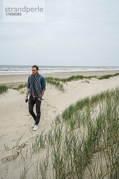 Ein Mann  der allein am Sandstrand von Zeeland  Niederlande  spaziert