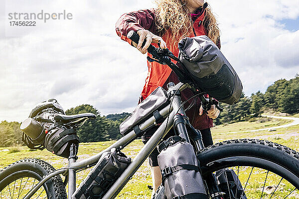 Frau genießt mit dem Mountainbike die Natur und übt Bikepacking