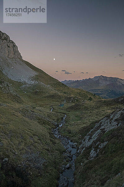 Gruppe von Menschen mit Zelten  die den Sonnenuntergang und den Mondaufgang beobachten  die Pyrenäen
