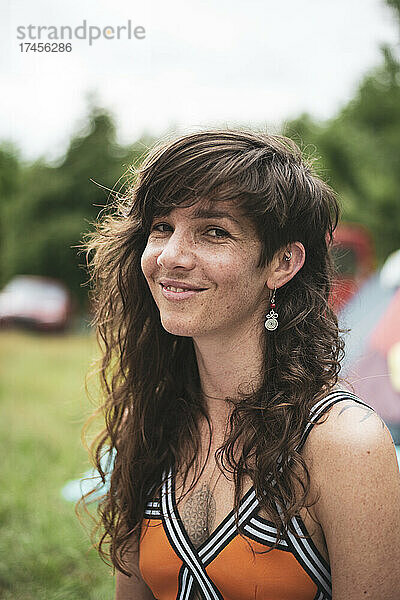Porträt einer natürlichen Frau mit langen Haaren und Sommersprossen auf dem Festival
