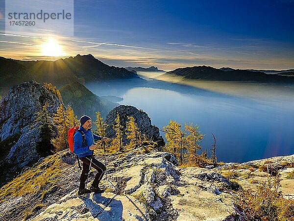 Bergsteiger steigt auf den Großen Schoberstein im Abendlicht mit Blick auf Attersee und Mondsee  hinten Schafberg und Drachenwand  Salzkammergut  Oberösterreich  Österreich  Europa