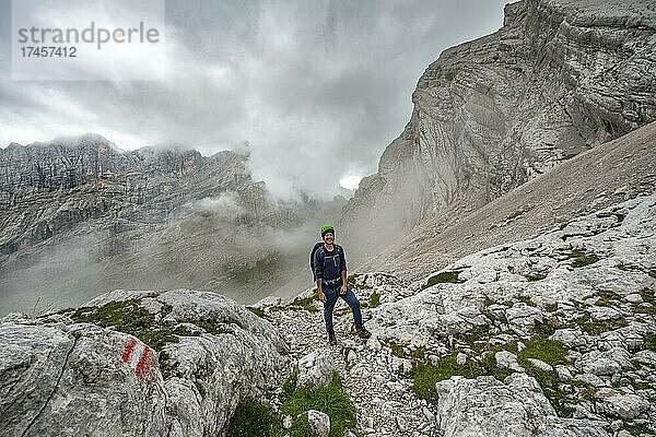 Wanderer  Bergsteiger auf einem Wanderweg zwischen felsigem wolkenverhangenen Gebirge am Forcella Sore de la Cengia  Sorapiss Umrundung  Dolomiten  Belluno  Italien  Europa