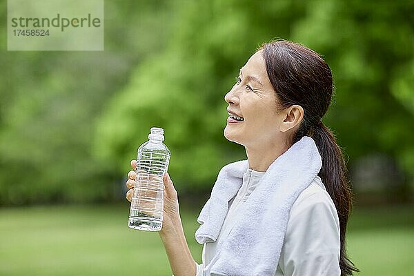 Eine japanische Seniorin trainiert in einem Stadtpark