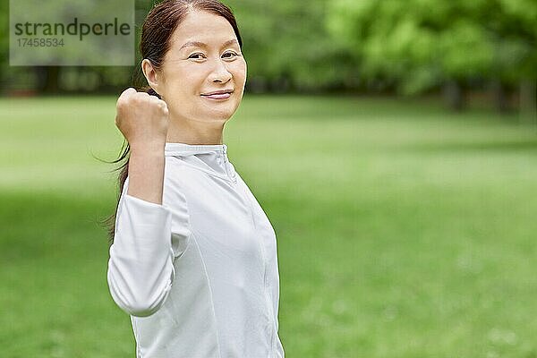 Eine japanische Seniorin trainiert in einem Stadtpark