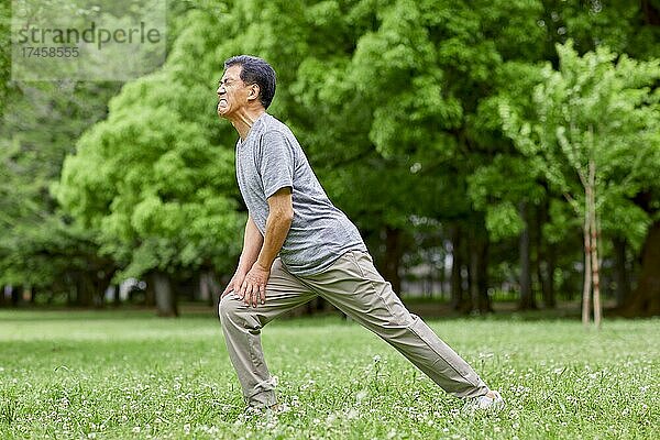 Japanischer älterer Mann trainiert in einem Stadtpark