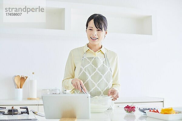Japanerin backt Kuchen in der Küche