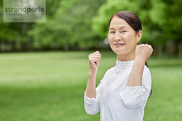 Eine japanische Seniorin trainiert in einem Stadtpark