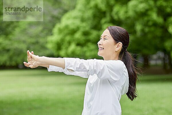 Eine japanische Seniorin trainiert in einem Stadtpark