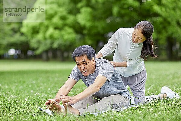 Japanisches Seniorenpaar trainiert in einem Stadtpark