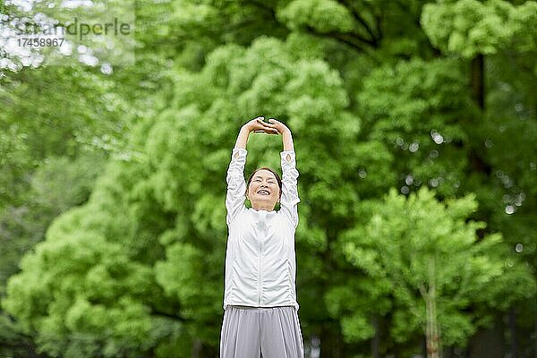 Eine japanische Seniorin trainiert in einem Stadtpark