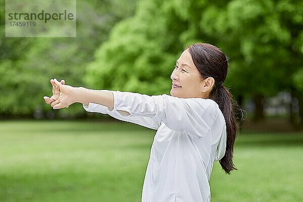 Eine japanische Seniorin trainiert in einem Stadtpark