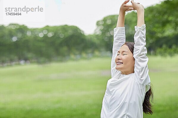 Eine japanische Seniorin trainiert in einem Stadtpark