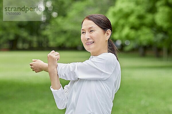 Eine japanische Seniorin trainiert in einem Stadtpark