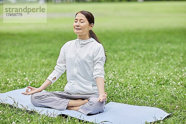 Eine japanische Seniorin trainiert in einem Stadtpark