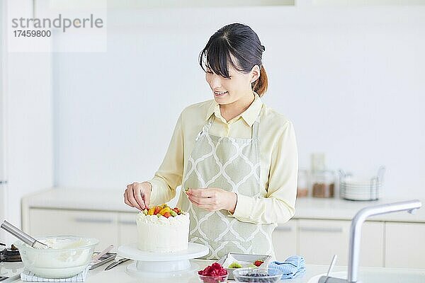 Japanerin backt Kuchen in der Küche