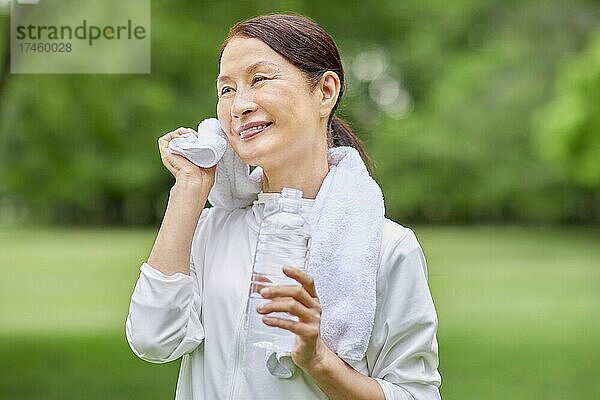 Eine japanische Seniorin trainiert in einem Stadtpark