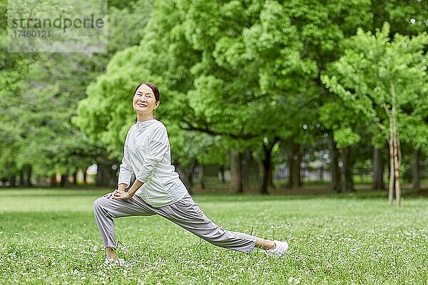 Eine japanische Seniorin trainiert in einem Stadtpark