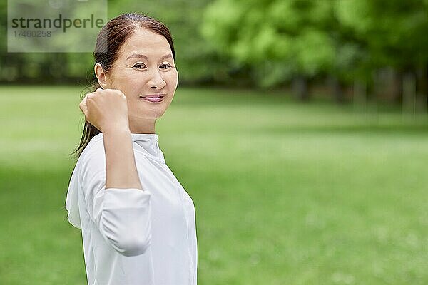 Eine japanische Seniorin trainiert in einem Stadtpark