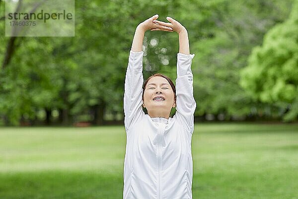 Eine japanische Seniorin trainiert in einem Stadtpark