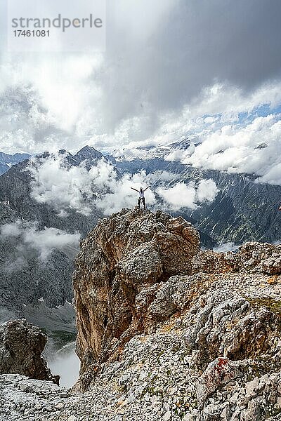 Wanderer auf einem Felsen streckt Arme in die Luft  Wettersteingrad  Patenkirchner Dreitorspitze  Wettersteingebirge  Garmisch-Partenkirchen  Bayern  Deutschland  Europa