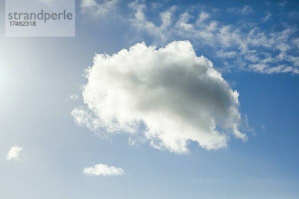 Eine einzelne Schäfchenwolken ziert nebst wenigen Federwolken bei starkem Wind den blauen Himmel