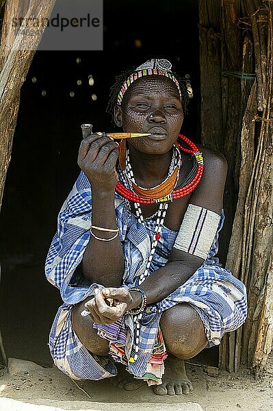 Frau mit Schönheitsnarben vom Stamm der Toposa raucht eine Pfeife  Ost-Äquatoria  Südsudan  Afrika