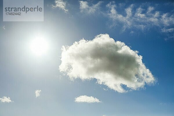 Die Sonne erstrahlt neben eíner imposanten (Cumulus) Wolke und wenigen Federwolken am blauen Himmel