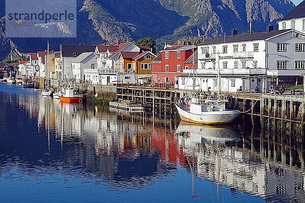 Fischerboote und Häuser spiegeln sich im ruhigen Wasser eines Hafens  Stille  Ruhe  Henningsvaer  Nordland  Lofoten  Norwegen  Europa