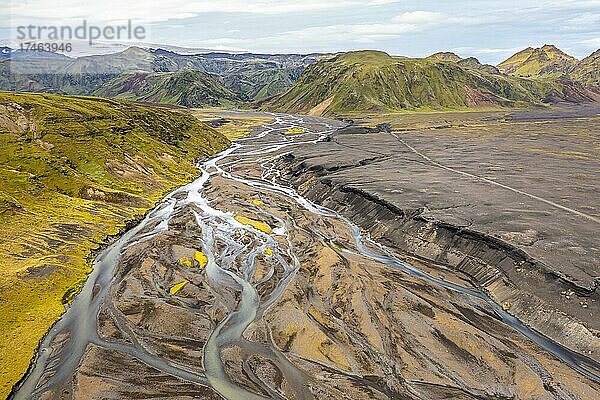 Fluss mit aufgefächerten Flussarmen durch schwarzen Lavasand  mit Moos bewachsene Berglandschaft  hinten Gletscher Höfðabrekkajökull  isländisches Hochland  Panorama  Luftaufnahme  Fluss Affrétisá  Þakgil  Island  Europa