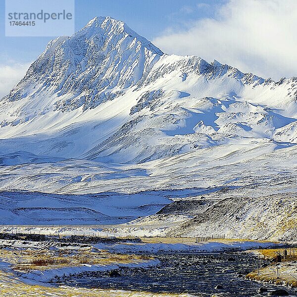 Tief verschneite  hohe Berge und Bach  Öxnadalur  Nordisland  Island  Europa