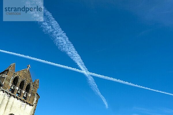 Blauer Himmel und Flugzeugspuren bilden ein Kreuz auf einer Kirche  Auvergne Rhone Alpes  Frankreich  Europa