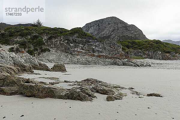Die zerklüfteten Felsen und die Küstenlinie der Atlantikküste am Grotto Beach  einem breiten Strand bei Hermanus.