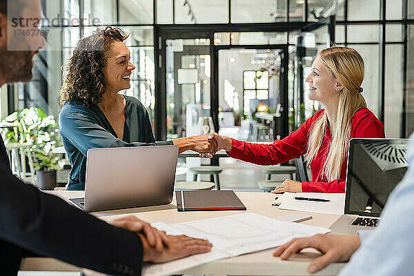 Geschäftsfrauen schütteln sich bei einem Treffen im Büro die Hand