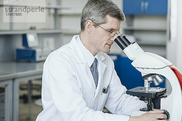 Forscher überprüfen Probe durch Mikroskop im Labor