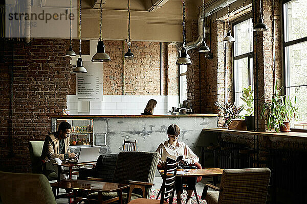 Mann und Teenager-Mädchen verbringen ihre Freizeit im modernen Café