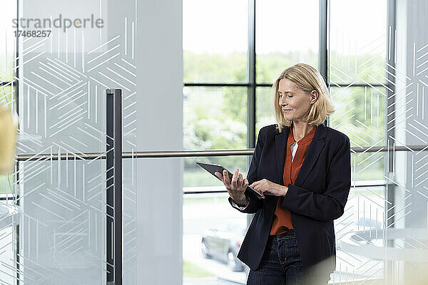 Geschäftsfrau arbeitet im Büro an einem digitalen Tablet