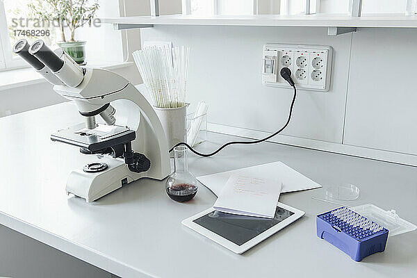Medizinische Probe und Mikroskop am Schreibtisch