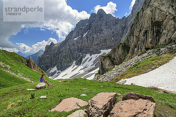 Wanderin sitzt auf einem Felsen und blickt auf die Berge in Kärnten  Österreich