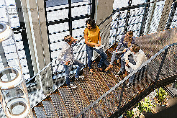 Geschäftsfrau diskutiert mit Kollegen auf der Treppe