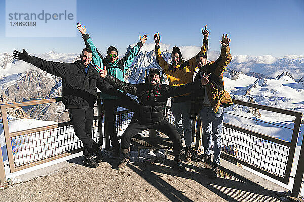Fröhliche Freunde mit erhobenen Händen am Aussichtspunkt Aiguille Du Midi  Mont Blanc  Chamonix  Frankreich