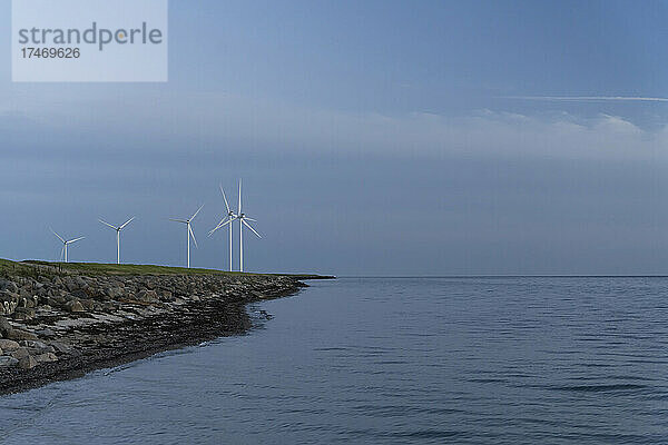 Windturbinen stehen in der Abenddämmerung an der Ostseeküste von Lolland-Falster