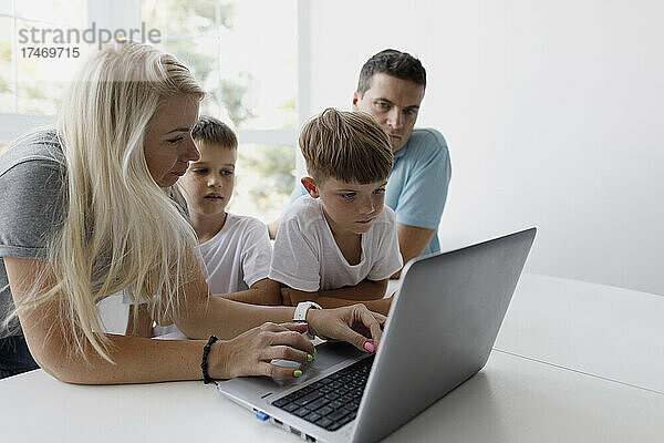 Mutter bringt Söhnen bei  zu Hause Laptop zu benutzen