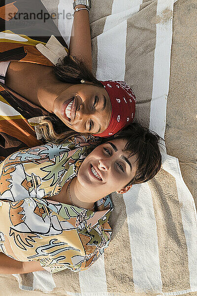 Lesbians relaxing on picnic blanket at beach